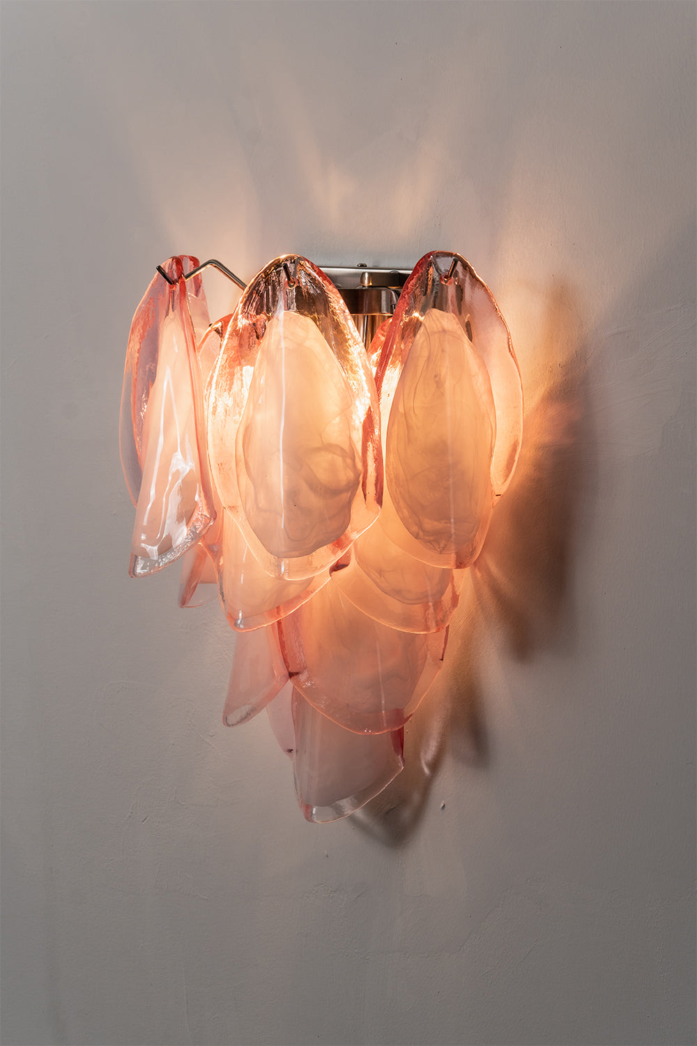 Elysian Bloom Glass Wall Lamp | Metal, Glass | Frontal view of the fully lit lamp casting a warm pink and golden glow on the wall | Isolated shot | vexa lamps