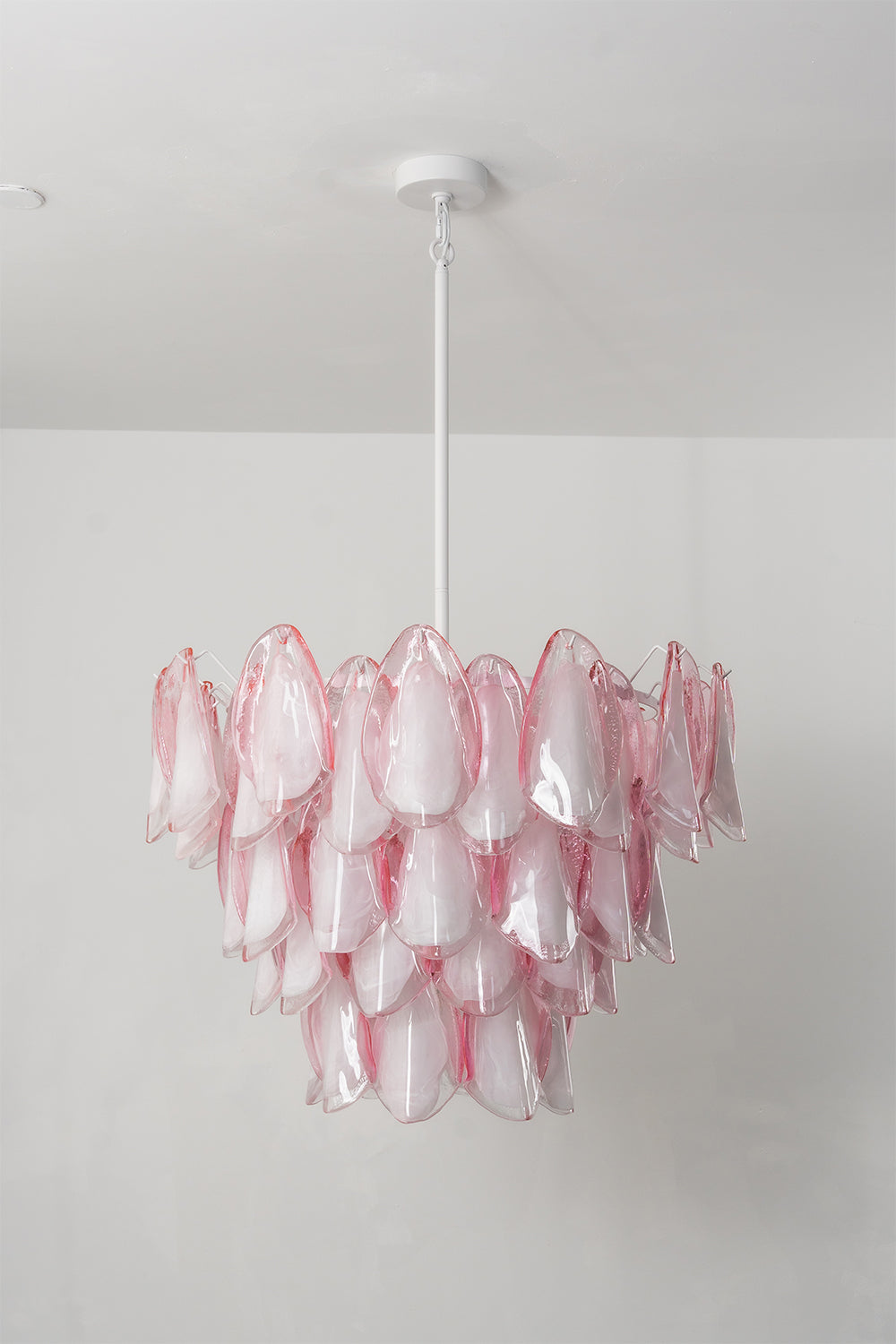 Elysian Bloom Rose Glass Chandelier | Metal, Glass | Frontal view of the unlit chandelier against a plain wall, highlighting the pink glass texture | Isolated shot | vexa lamps