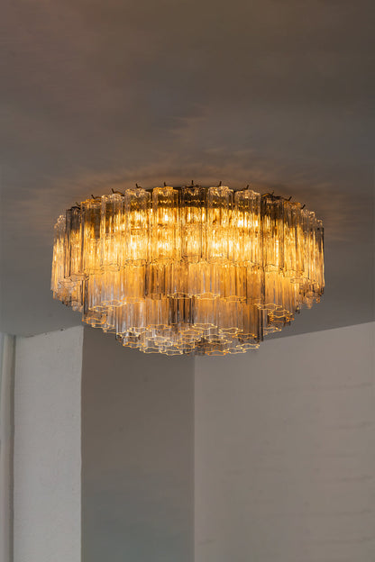 Elysian Tiered Fluted Ceiling Light | Glass, Metal | Side view of the illuminated multi-tiered glass ceiling light projecting a warm, inviting glow on a white studio ceiling | vexa lamps