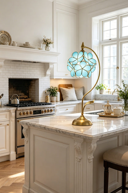 Evanthe Blossom Stained Glass Table Lamp | Stained Glass, Metal | Blue variant standing on a pristine white marble kitchen island counter as elegant statement accent lighting | vexa lamps