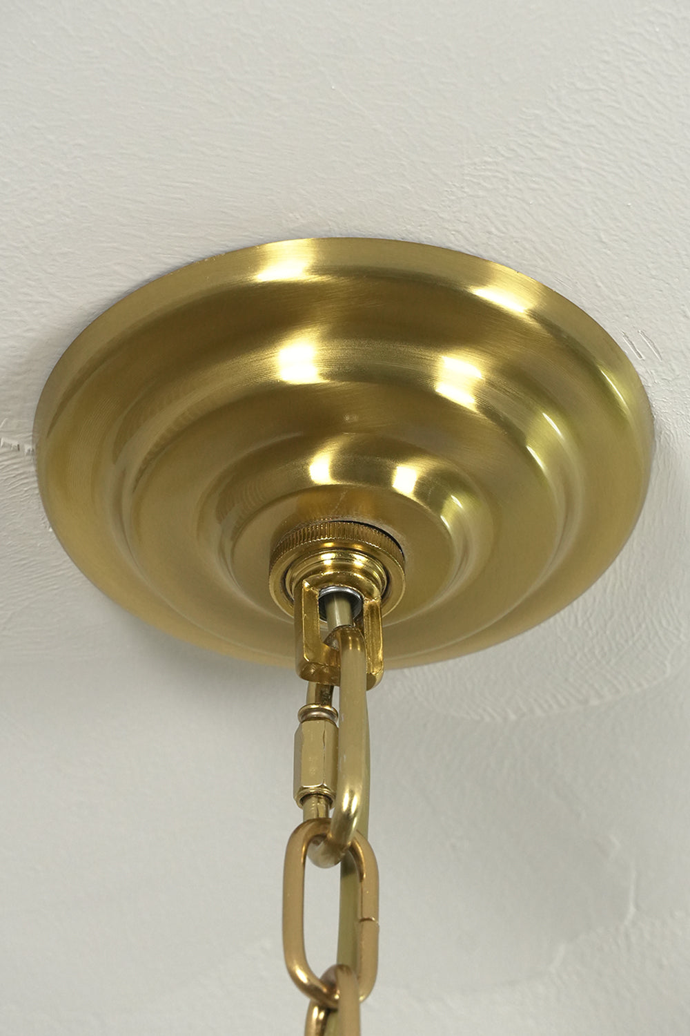 Brass finish ceiling canopy and chain connection | Metal | Close-up of the mounting hardware for chandelier | vexa lamps