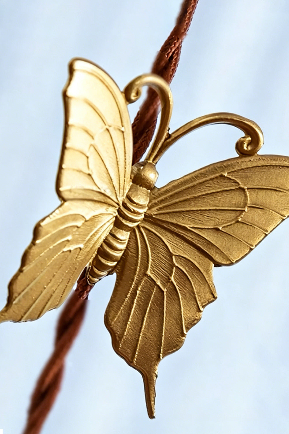 Faye Pastel Scalloped Glass Pendant Lamp | Glass, Metal | Macro close-up focus on the intricate details of the sculpted golden brass butterfly accent on the cord | Detail shot | vexa lamps