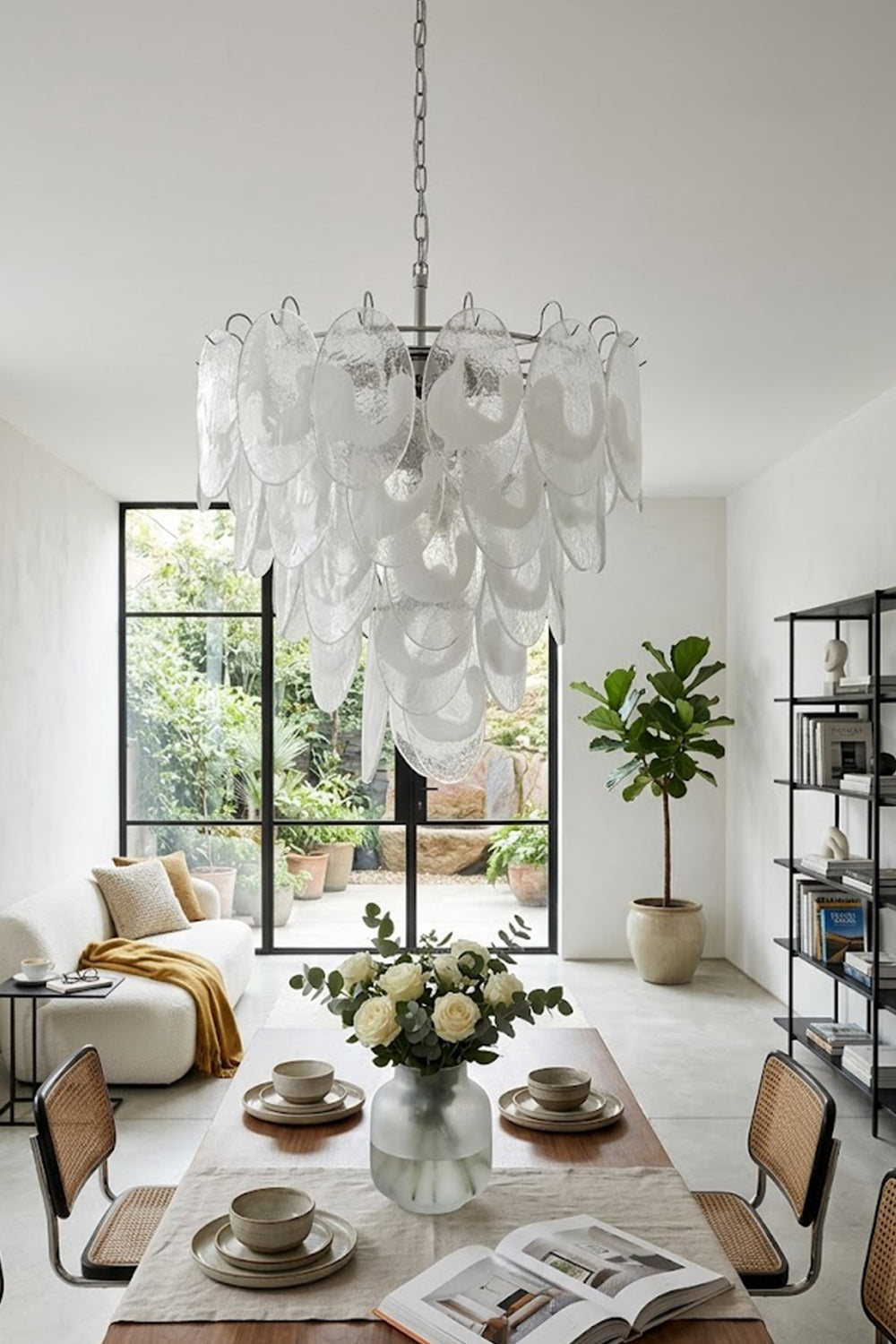Glass leaf cluster chandelier over a set dining table | Metal, Glass | Centered in a modern dining room with chairs | vexa lamps
