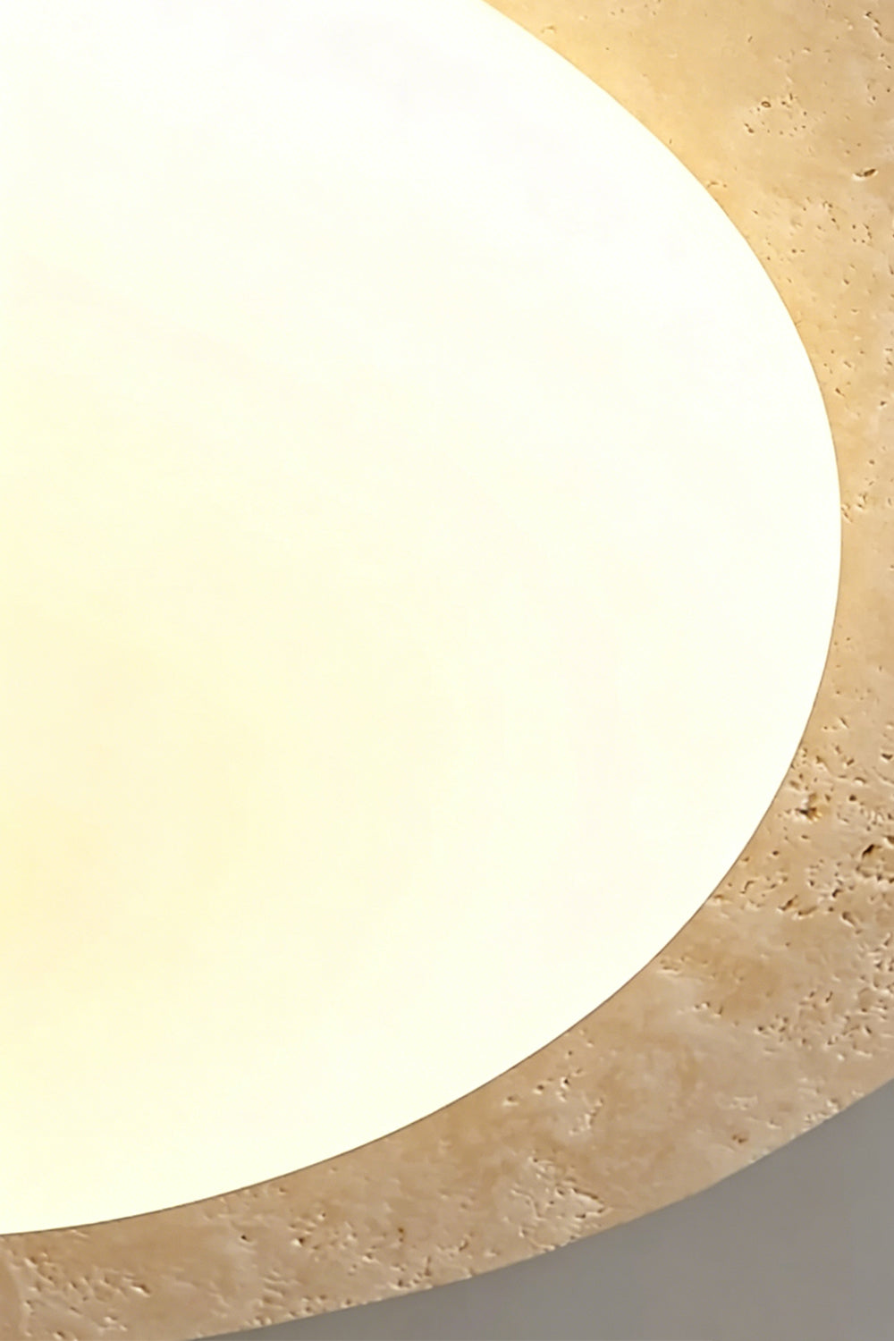 Travertine Ceiling Light Detail | Travertine, Glass | Extreme close-up of lit stone halo edge | Emphasizing the natural voids and texture | vexa lamps