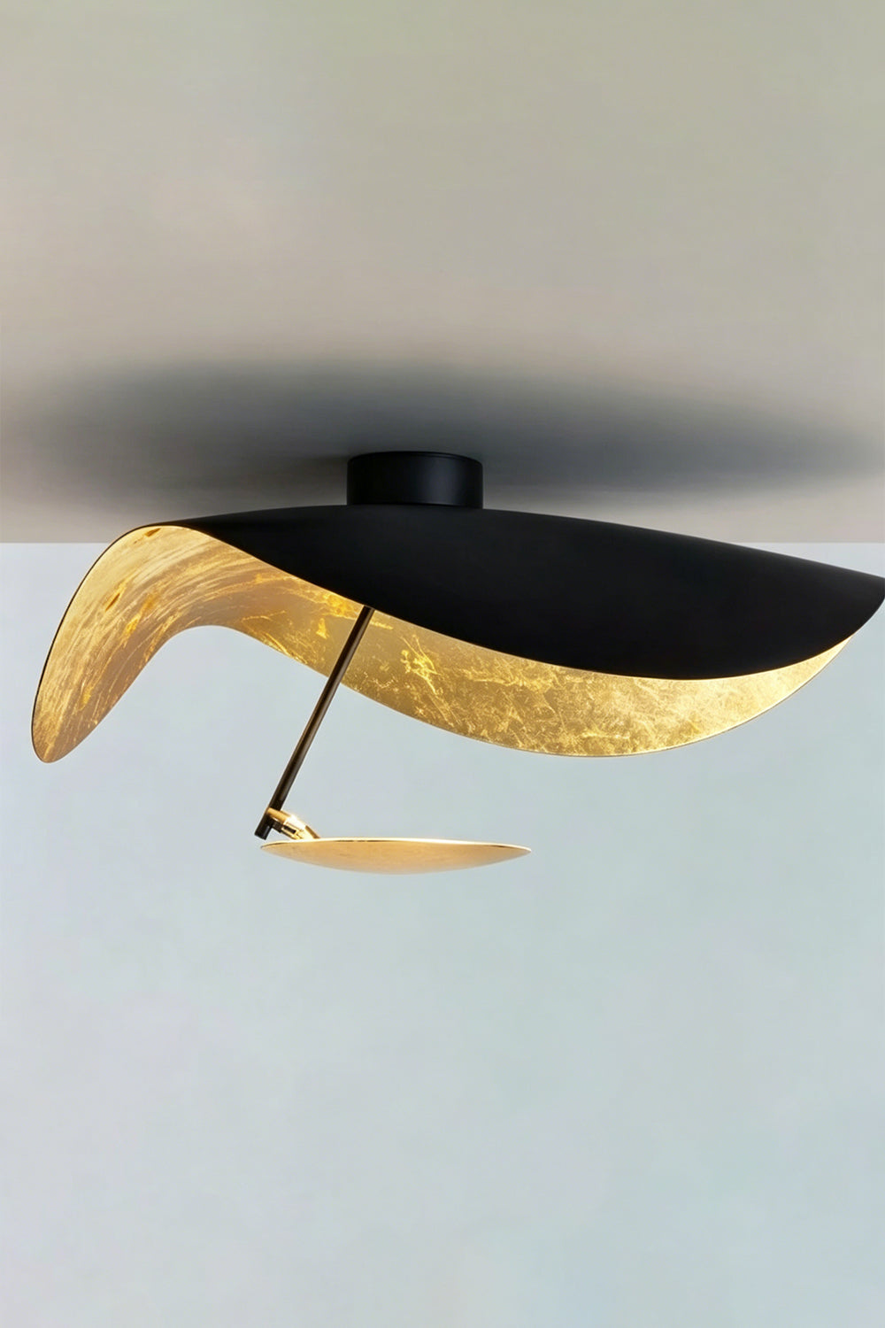 Gold-Tone Sculptural Ceiling Light showcasing a wave-like black and gold design, ideal for modern decor.