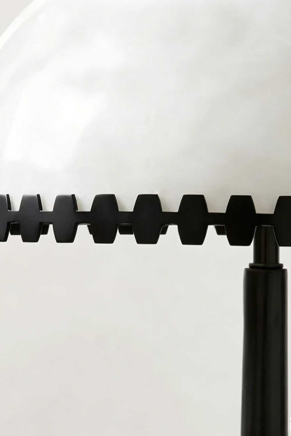 Helena Alabaster Trim Table Lamp | Notched Trim Detail | Macro close-up focus highlighting the unique serrated geometric black metal trim bordering the white translucent alabaster shade | Detail shot | vexa lamps