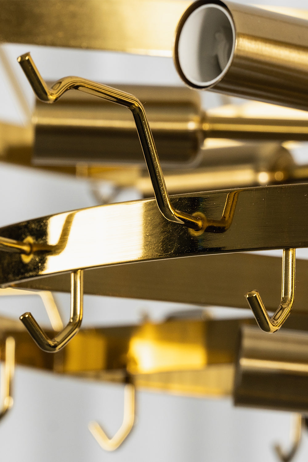 Close-up of the Isadora Tiered Amber Glass Chandelier showcasing its golden hooks and metal structure.