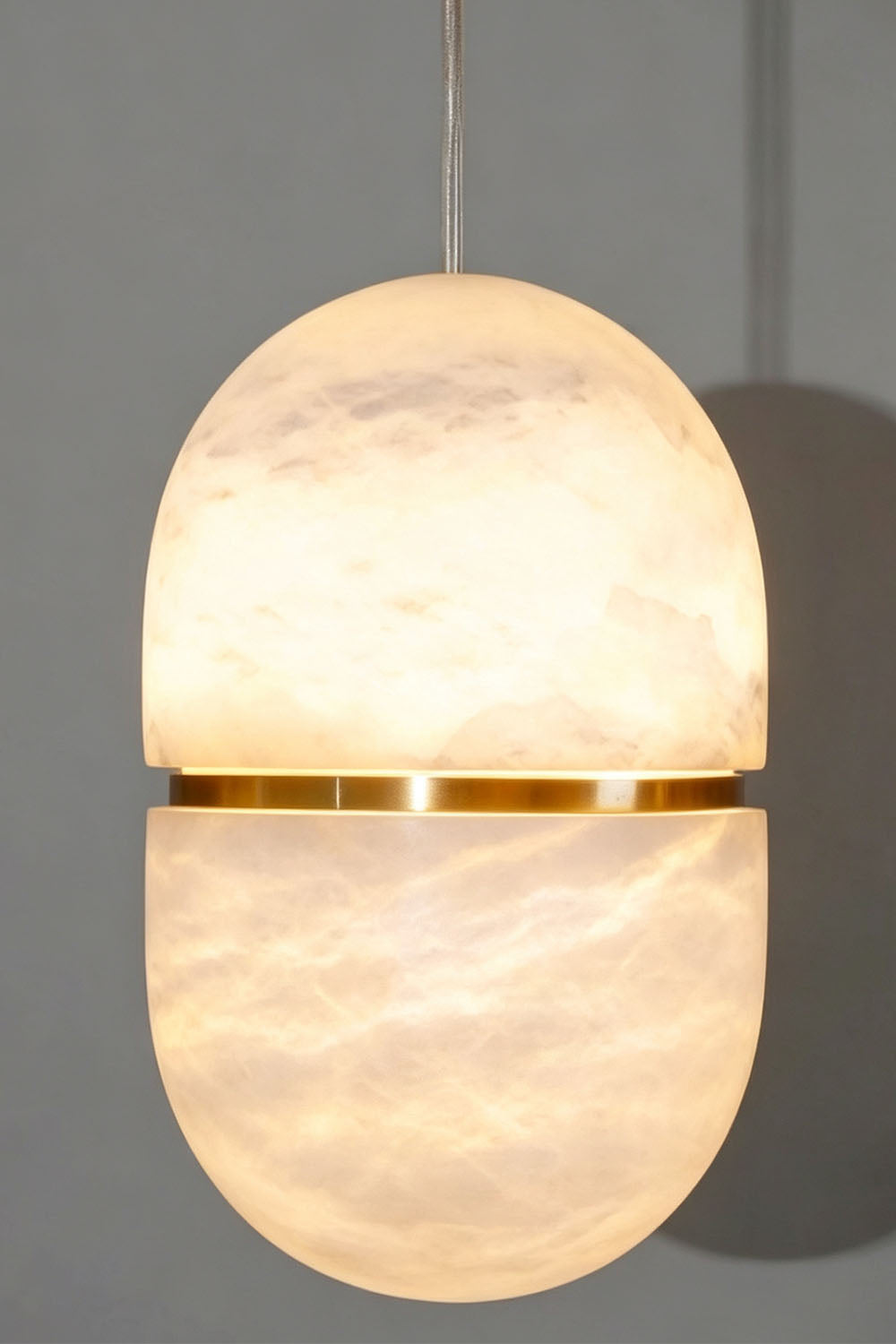 Isaline Banded Capsule Alabaster Pendant Light featuring a sleek design with a gold band accent.