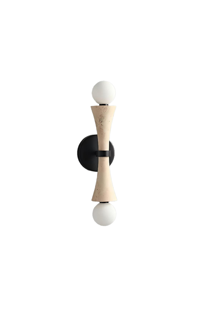 Katia Travertine Hourglass Wall Lamp | Travertine, Metal | Isolated unlit view of a modern architectural wall sconce featuring an hourglass-shaped natural beige travertine stone body and dual round glass globe bulbs on a black bracket | White background | vexa lamps