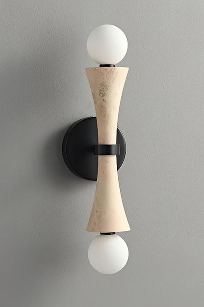 Katia Travertine Hourglass Wall Lamp | Travertine, Metal | Studio variant product view featuring the classic natural beige travertine stone hourglass body paired with black hardware | vexa lamps