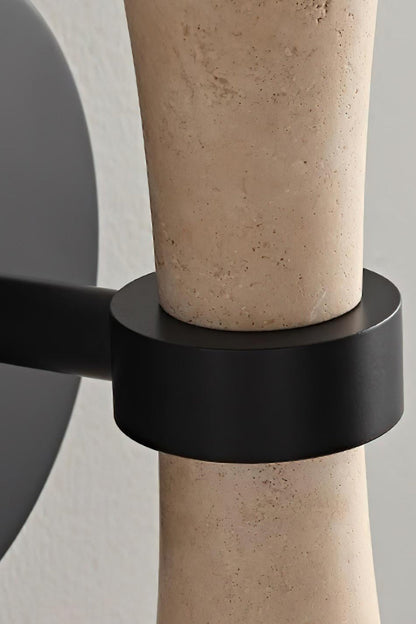 Katia Travertine Hourglass Wall Lamp | Travertine, Metal | Macro close-up focusing on the seamless connection of the matte black metallic wall base mount and holding ring structure | Detail shot | vexa lamps