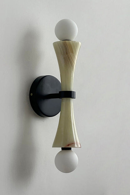 Katia Travertine Hourglass Wall Lamp | Travertine, Metal | Studio variant product view featuring an olive green tinted stone hourglass body paired with matte black hardware fittings | vexa lamps