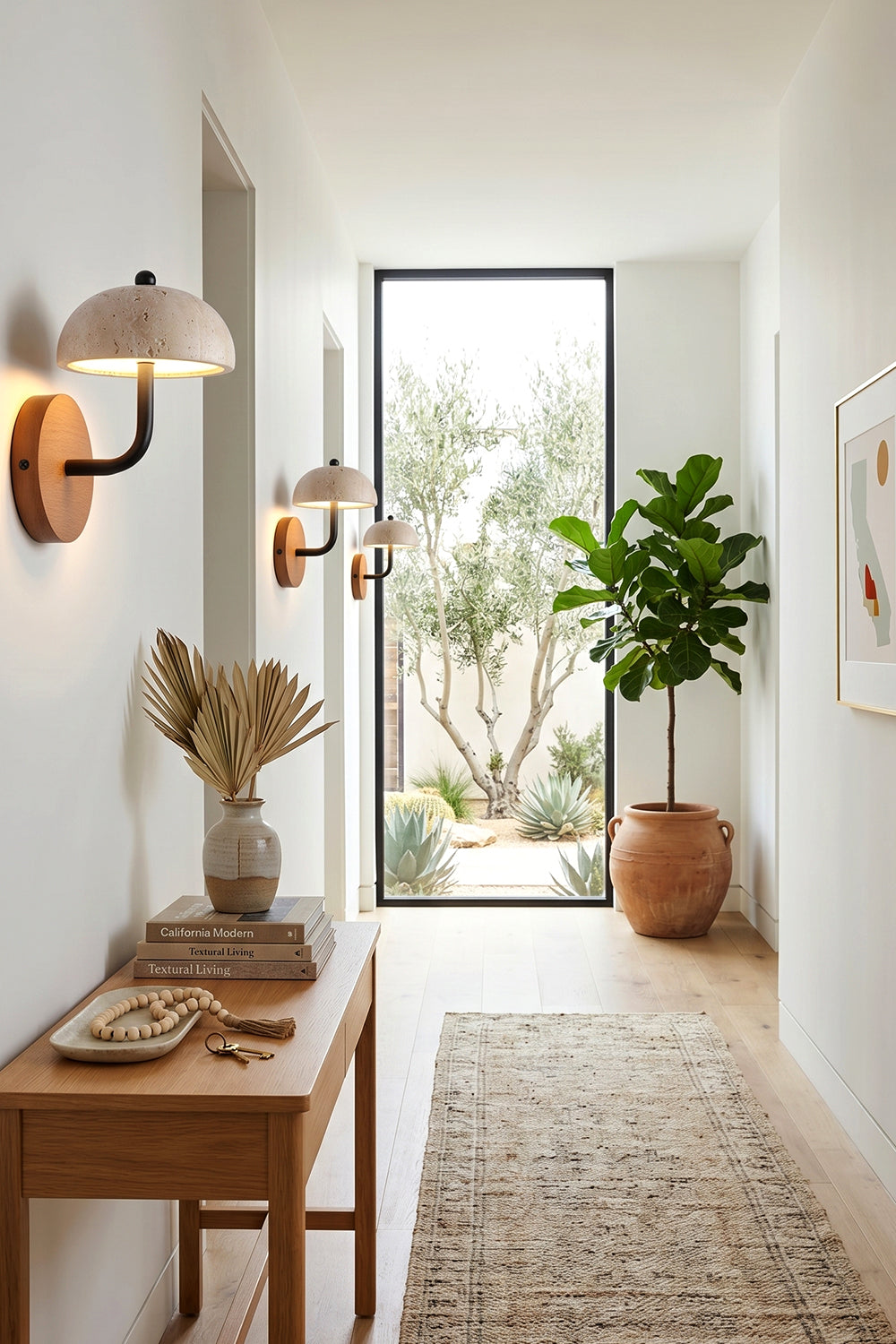 Koba Travertine Mushroom Wall Lamp | Travertine, Wood, Metal | Mounted along a bright modern hallway above a wooden console table with earthy decorative pieces | vexa lamps