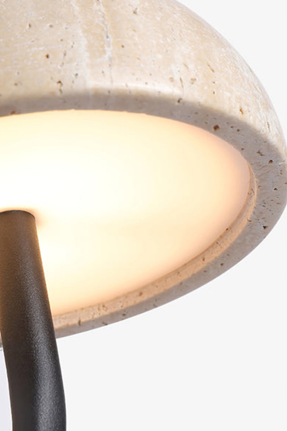 Koba Travertine Mushroom Wall Lamp | Travertine, Wood, Metal | Detailed close-up showing the warm diffused downlight glowing underneath the porous travertine mushroom shade | Detail shot | vexa lamps