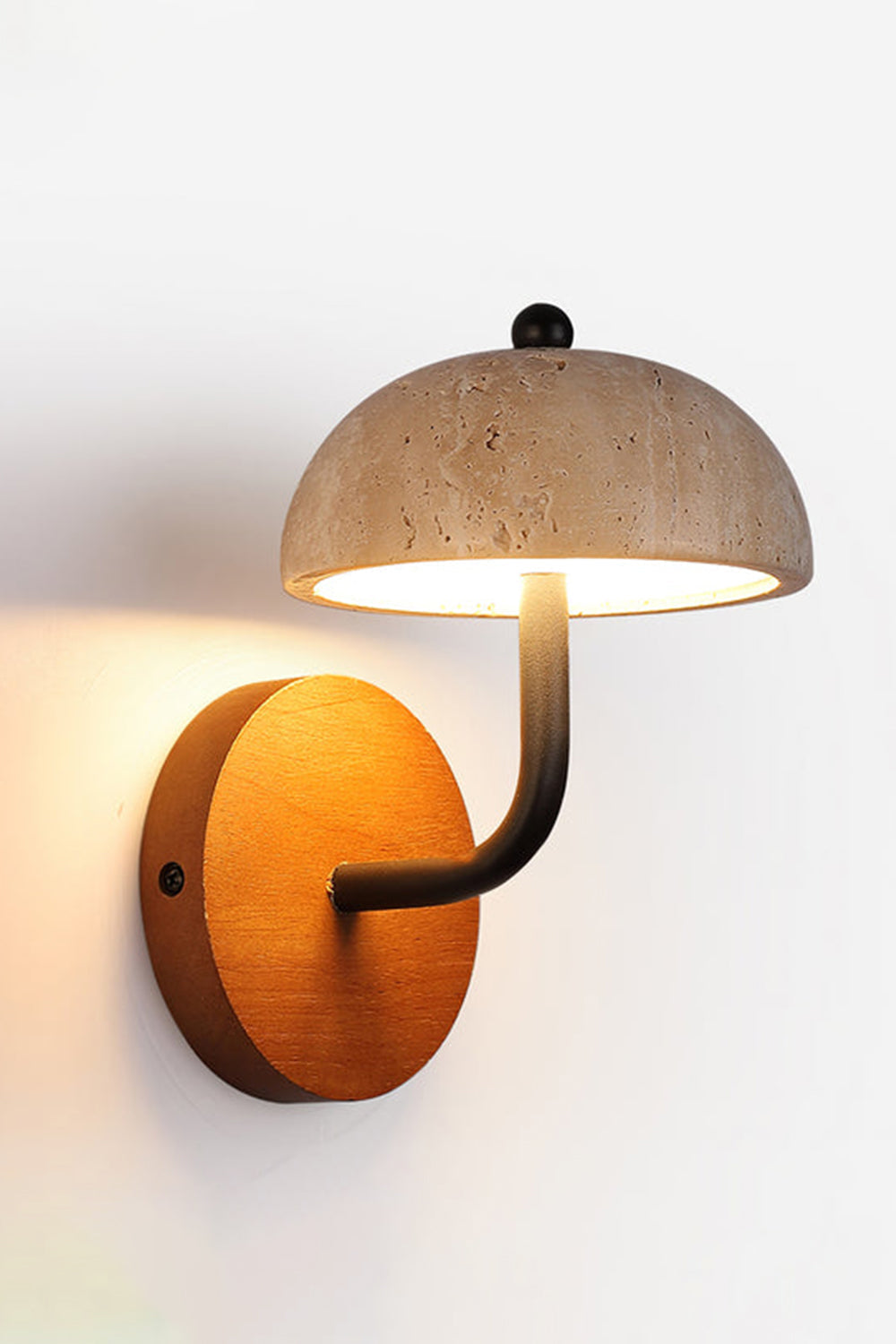 Koba Travertine Mushroom Wall Lamp | Travertine, Wood, Metal | Front view of the fully illuminated stone mushroom sconce casting a soft backlight halo on a plain wall | vexa lamps