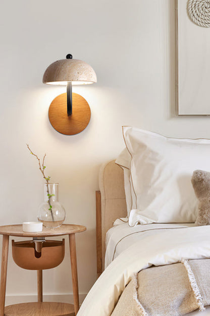 Koba Travertine Mushroom Wall Lamp | Travertine, Wood, Metal | Mounted as a cozy bedside reading light above a wooden nightstand in a soft cream-toned bedroom | vexa lamps