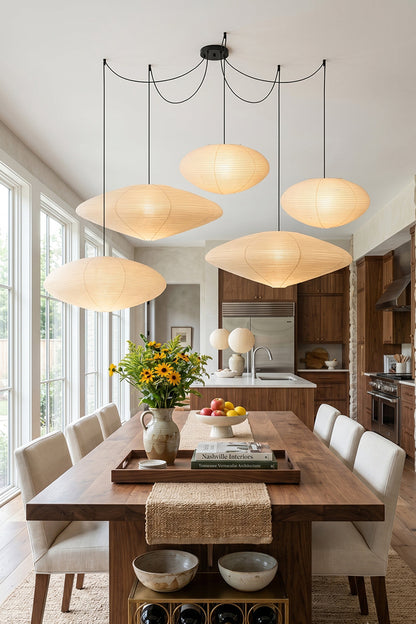Komorebi Mulberry Paper Pendant Light | Paper, Bamboo | Four multi-shaped mulberry paper lanterns hanging elegantly as a clustered centerpiece over a long oak dining table | vexa lamps