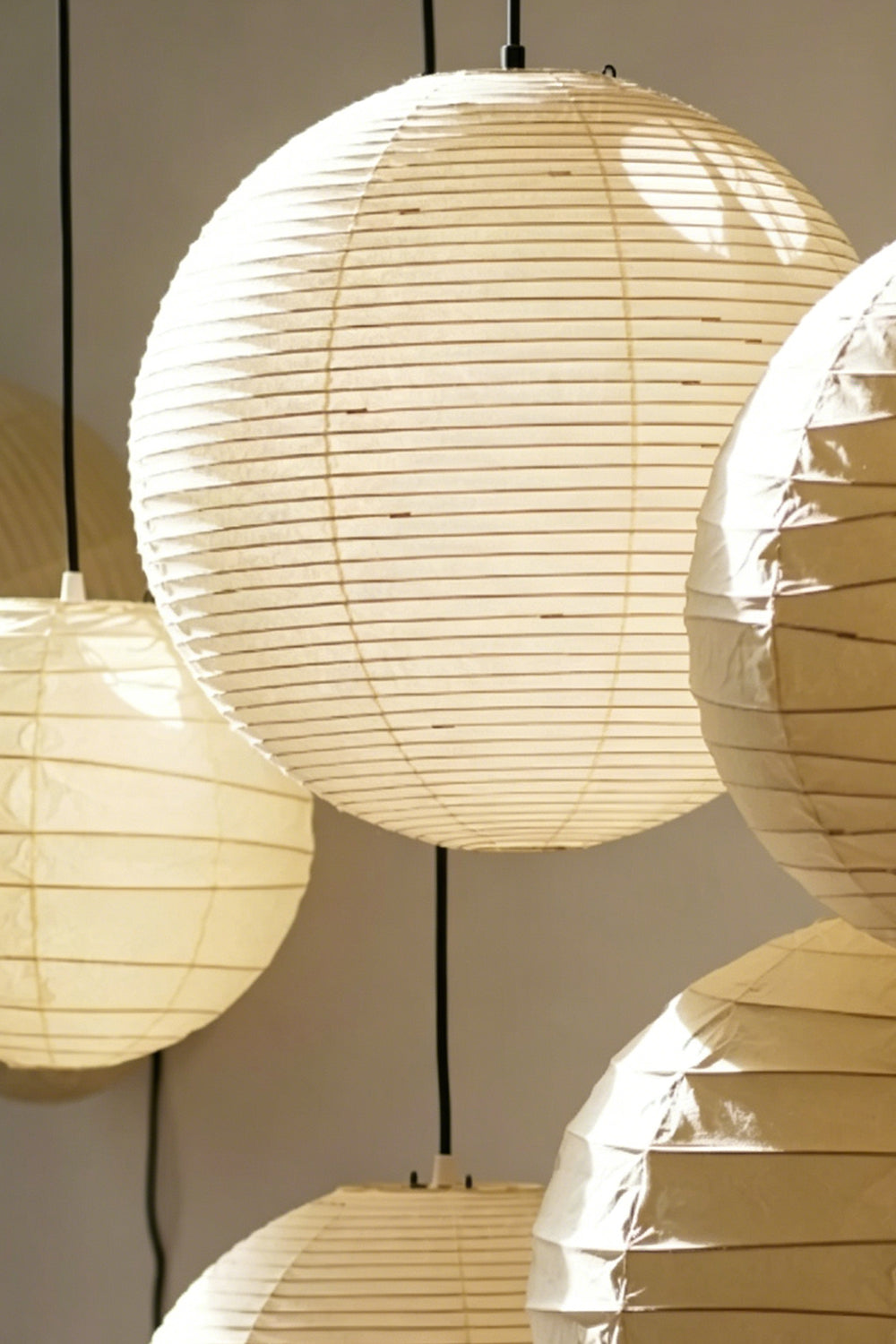 Komorebi Mulberry Paper Pendant Light | Paper, Bamboo | Close-up focus on overlapping illuminated mulberry paper shades showcasing the fine bamboo ribbing and texture | Detail shot | vexa lamps