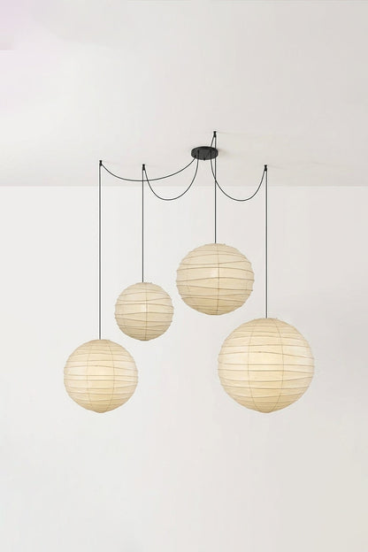 Komorebi Mulberry Paper Pendant Light | Paper, Bamboo | Studio view of a fully lit 4-light cluster combination radiating a cozy golden ambient light against a white wall | vexa lamps