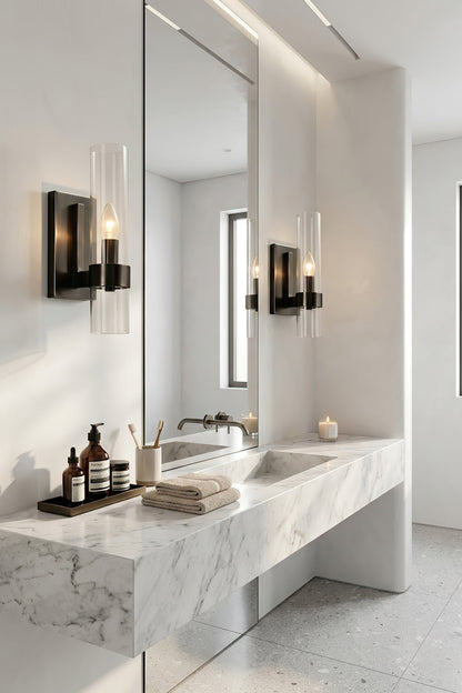 Pair of black linear glass wall sconces | Brass, Glass | Flanking a bathroom mirror over a marble counter | vexa lamps