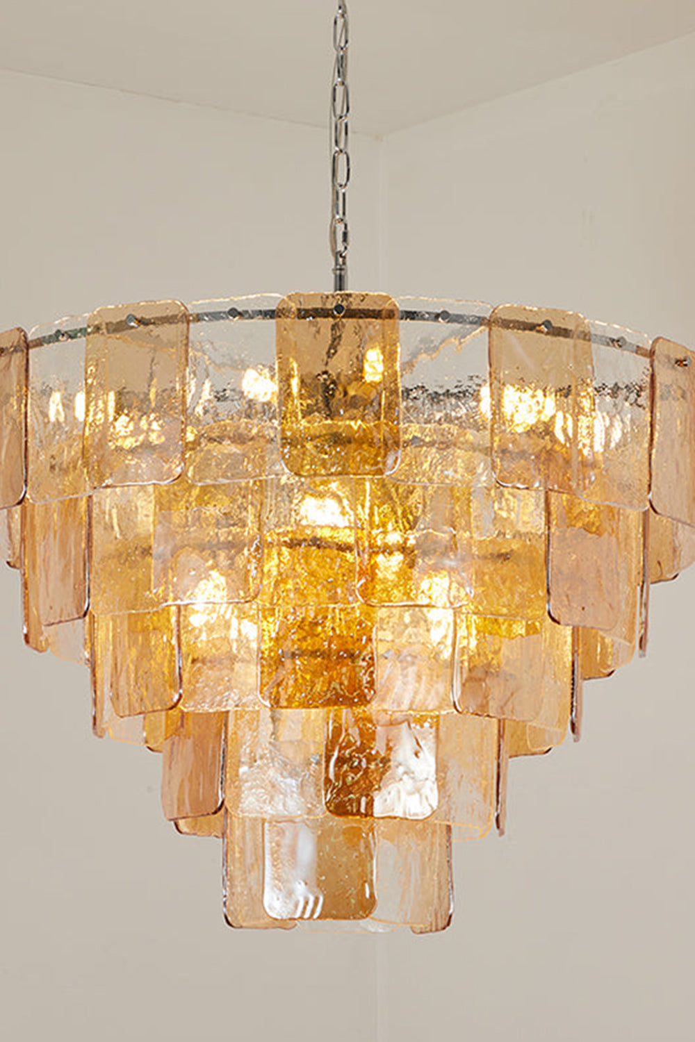 Lucia Tiered Amber Glass Chandelier | Glass, Metal | Detailed studio shot highlighting the overlapping concentric layers of glowing amber glass tiles and chrome hanging chain | Detail shot | vexa lamps