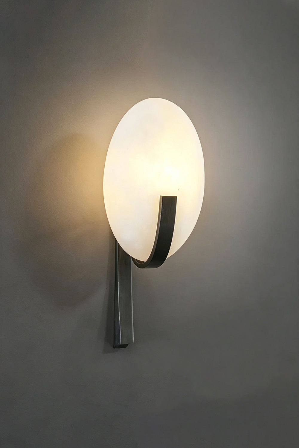 Lunar Veil lamp with warm illumination | Side perspective on dark textured wall | Emphasizing diffused light pattern | vexa lamps