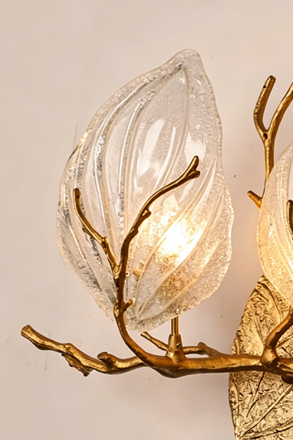 Magnolia Arbor Brass Wall Lamp | Brass, Glass | Close-up focus on the illuminated leaf-shaped clear glass shade and lifelike golden twig | Detail shot | vexa lamps