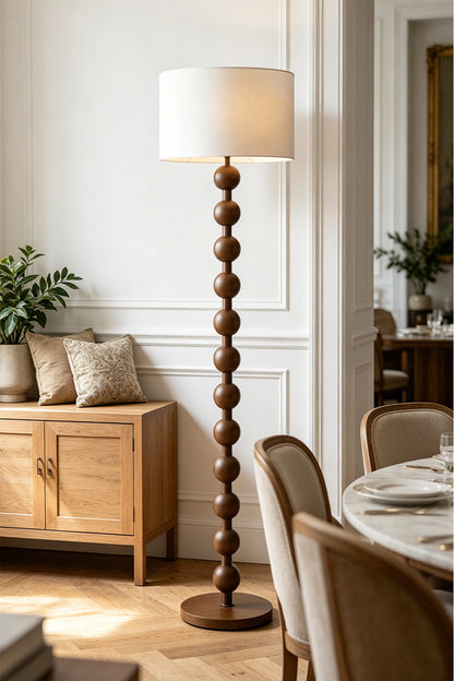 Marlow Stacked Wood Floor Lamp | Wood, Fabric | Providing warm inviting light in a sophisticated dining room corner next to a wooden sideboard and upholstered dining chairs | vexa lamps