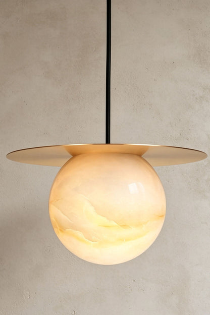 Marne Alabaster Sphere Brass Pendant Light | Natural Alabaster and Brass | Illuminated product shot showing the brass disc shade and alabaster globe | vexa lamps