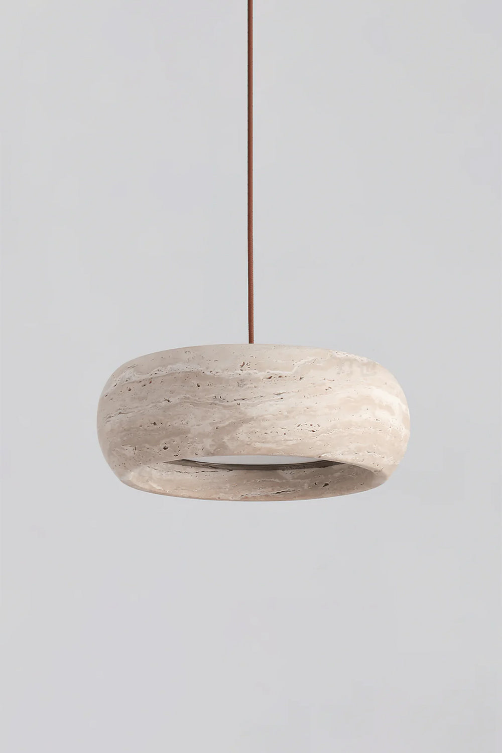 Maro Travertine Donut Pendant Light | Travertine, Metal | Studio front profile view of the unlit organic beige stone donut hanging lamp displayed against a plain grey backdrop | vexa lamps