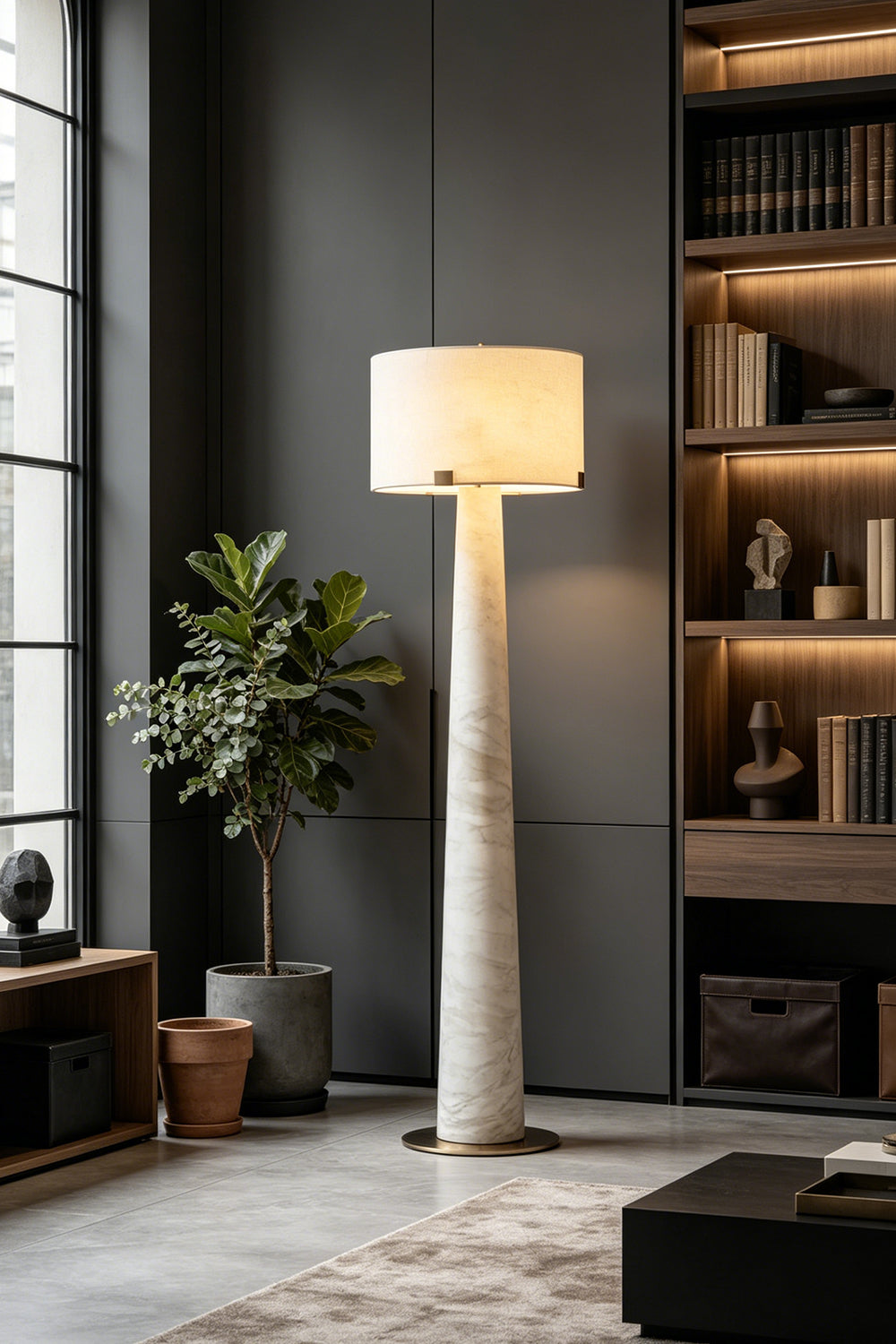 Meridian Column Alabaster Floor Lamp | Alabaster, Brass | Ambient lighting in a dark minimalist living area with bookshelves | vexa lamps