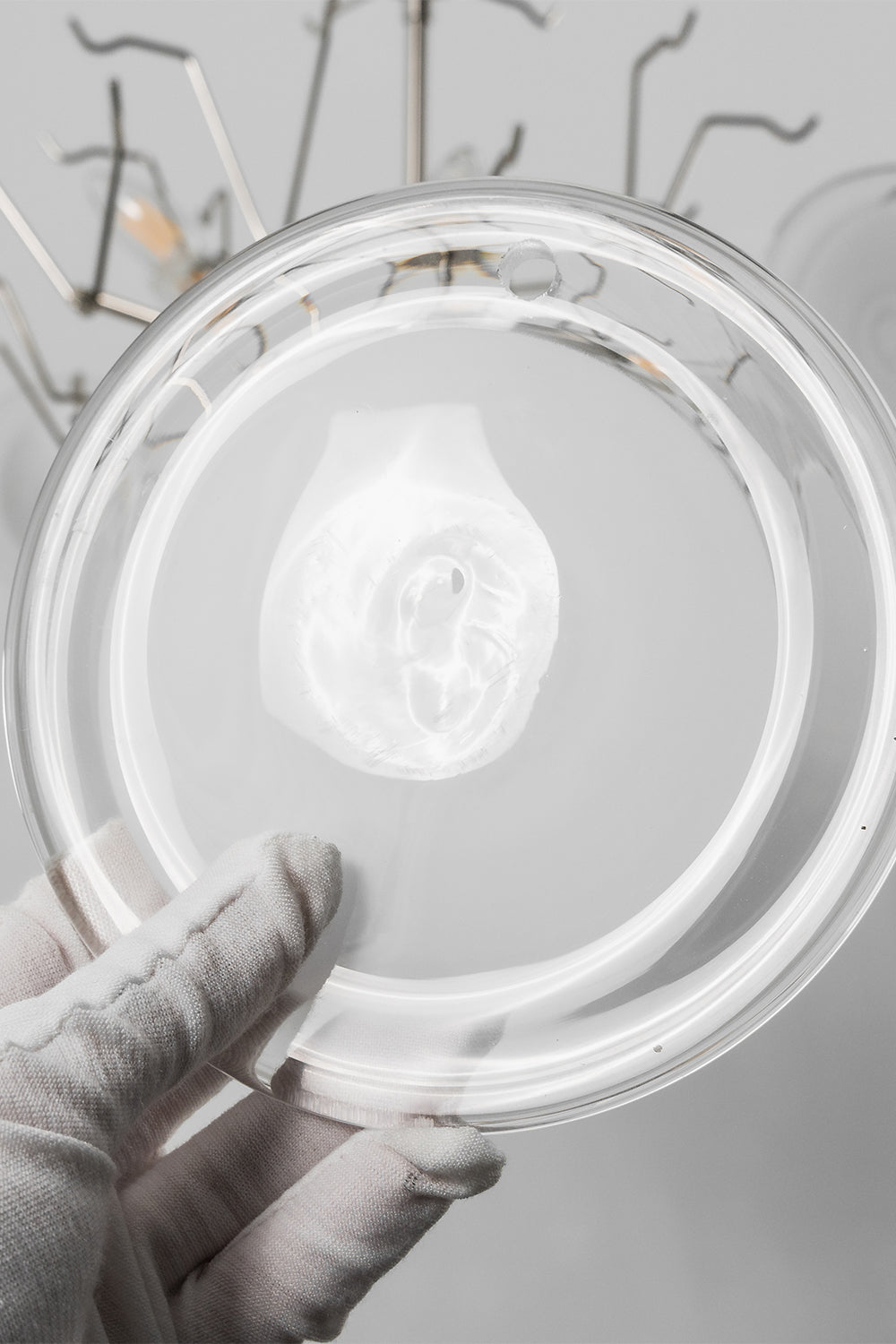 Mirella Circular Glass Pane Ceiling Light | Glass Pane Detail | Close-up shot showing a white-gloved hand holding an individual circular frosted white glass disc plate component | Detail shot | vexa lamps