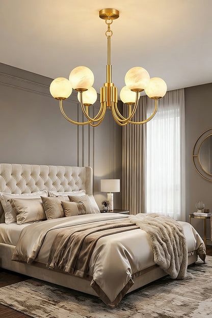 Modern brass chandelier with alabaster globes | Alabaster, Brass | Mounted in a bedroom above a bed with tufted headboard | vexa lamps