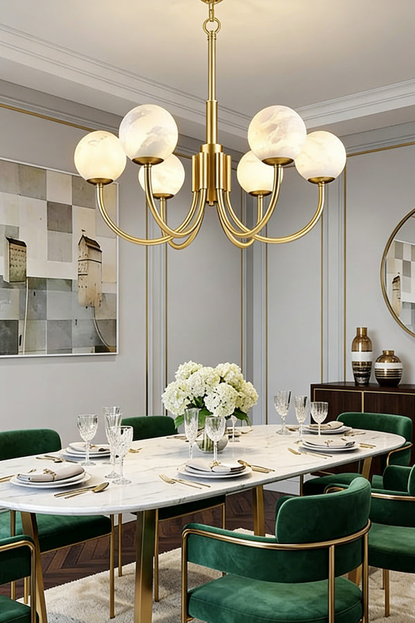 Minimalist brass globe chandelier | Alabaster, Brass | Installed in a bright dining room with green velvet chairs | vexa lamps