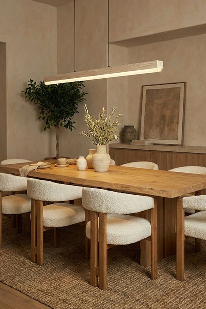 Linear stone pendant over a round-edge dining table | Travertine, Wood, Acrylic | Interior scene with white upholstered chairs | vexa lamps