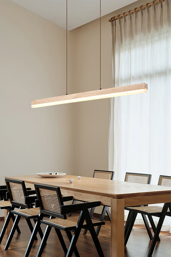 Travertine linear pendant lamp in a bright dining room | Travertine, Wood, Acrylic | Over a large wooden table with black chairs | vexa lamps