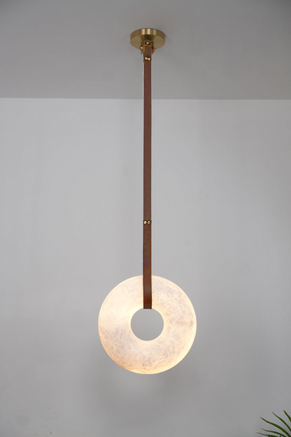 Nerissa Alabaster Ring Leather Pendant Light | Natural Alabaster, Leather and Brass | Single-strap disc variant full view hanging on a plain backdrop | vexa lamps