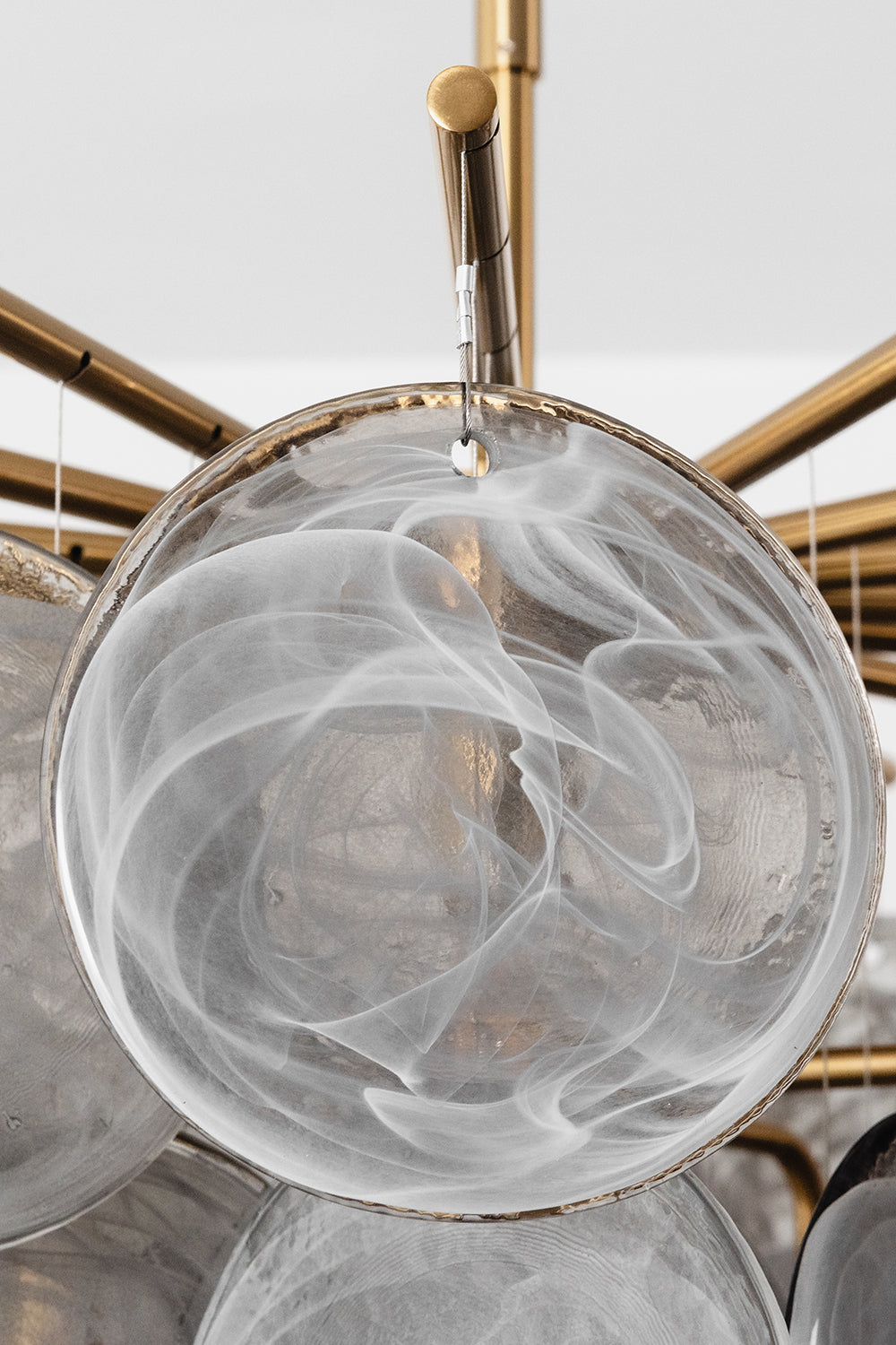 Nimbus Smoked Glass Disc Chandelier close-up showing hand-blown glass disc with a swirling smoke design.