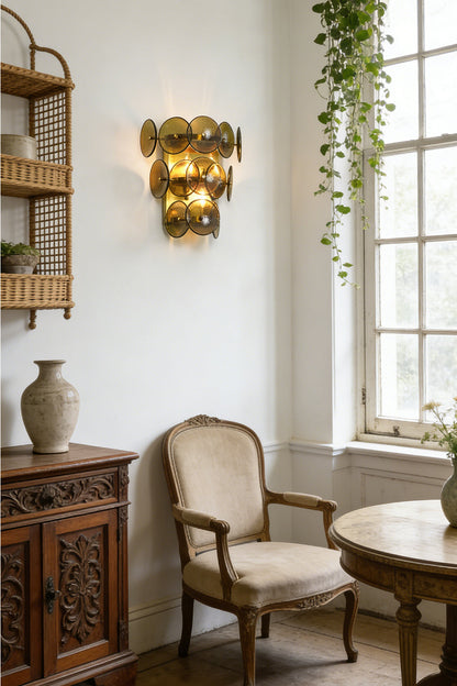 Lit tiered olive green glass wall lamp | Metal, Glass | Installed in a sunlit room with wicker furniture | vexa lamps