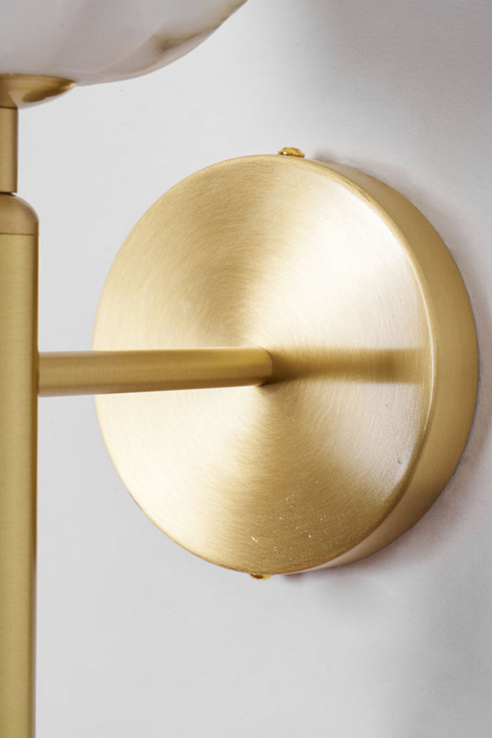 Ondine Alabaster Blossom Wall Sconce | Natural Alabaster and Brass | Close-up side view of the polished brass mounting hardware and circular base flush against a wall | vexa lamps