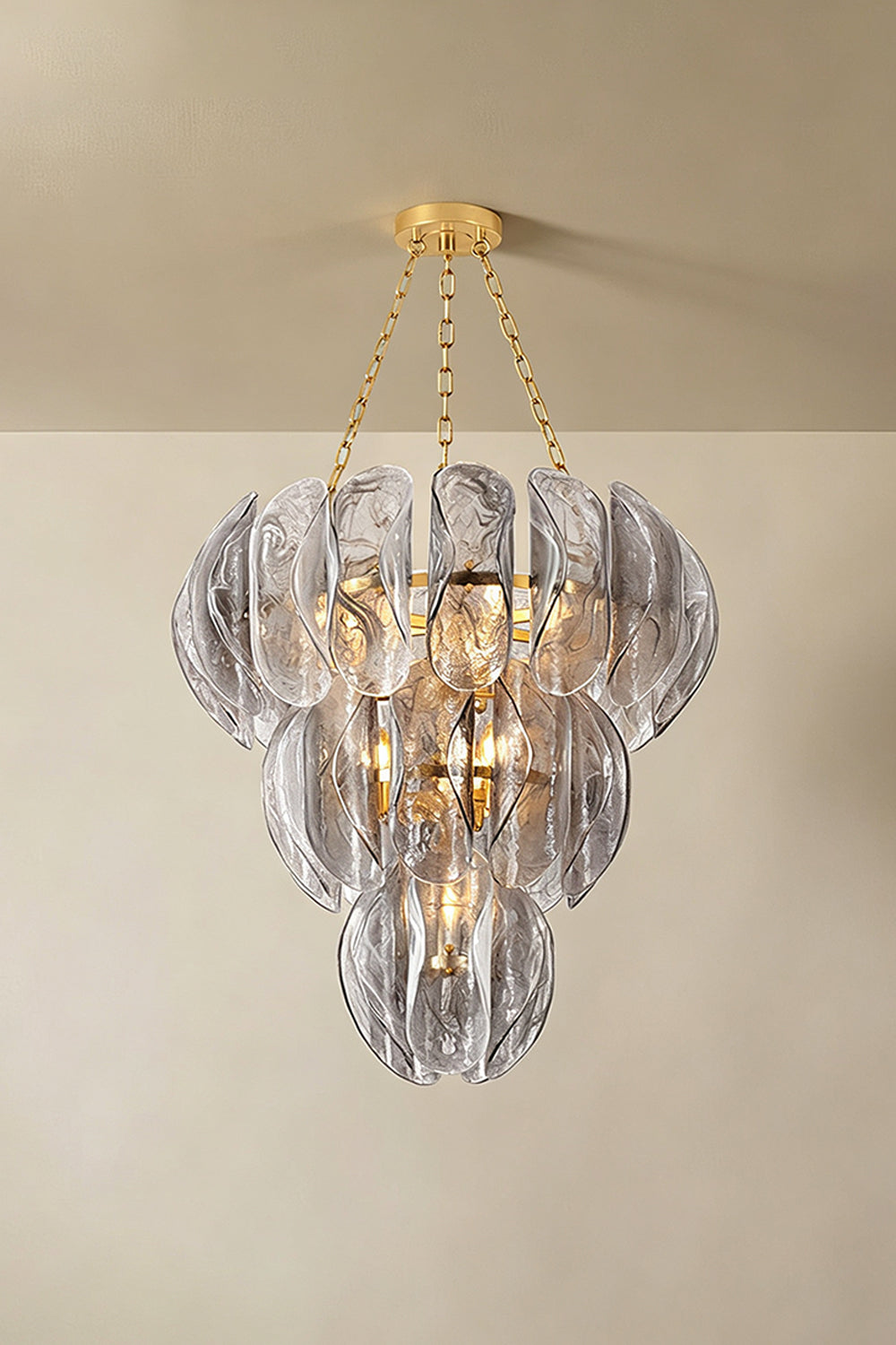 Ondine Cascading Leaf Glass Chandelier | Textured Smoked Glass and Gold Metal | Displayed hanging from a plain plaster ceiling casting soft warm ambient illumination in a room | vexa lamps