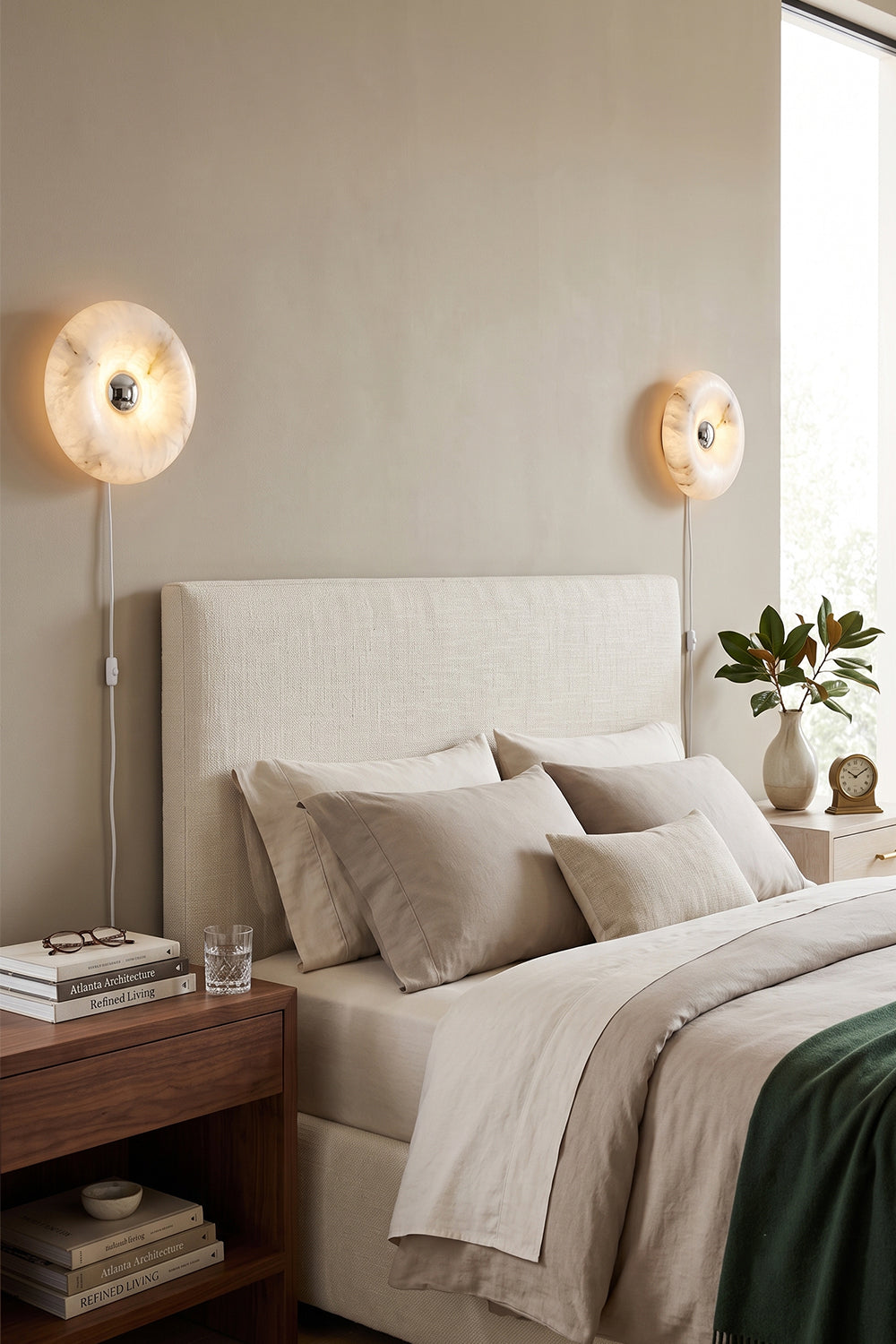 Cozy bedroom with Ondine Ring Alabaster Wall Sconce lighting, featuring a neutral color palette and modern decor.