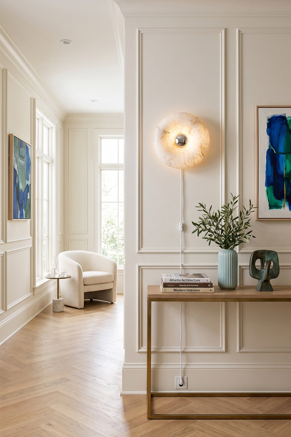 Ondine Ring Alabaster Wall Sconce illuminating a modern entryway with a gold-toned wall plate and natural alabaster design.