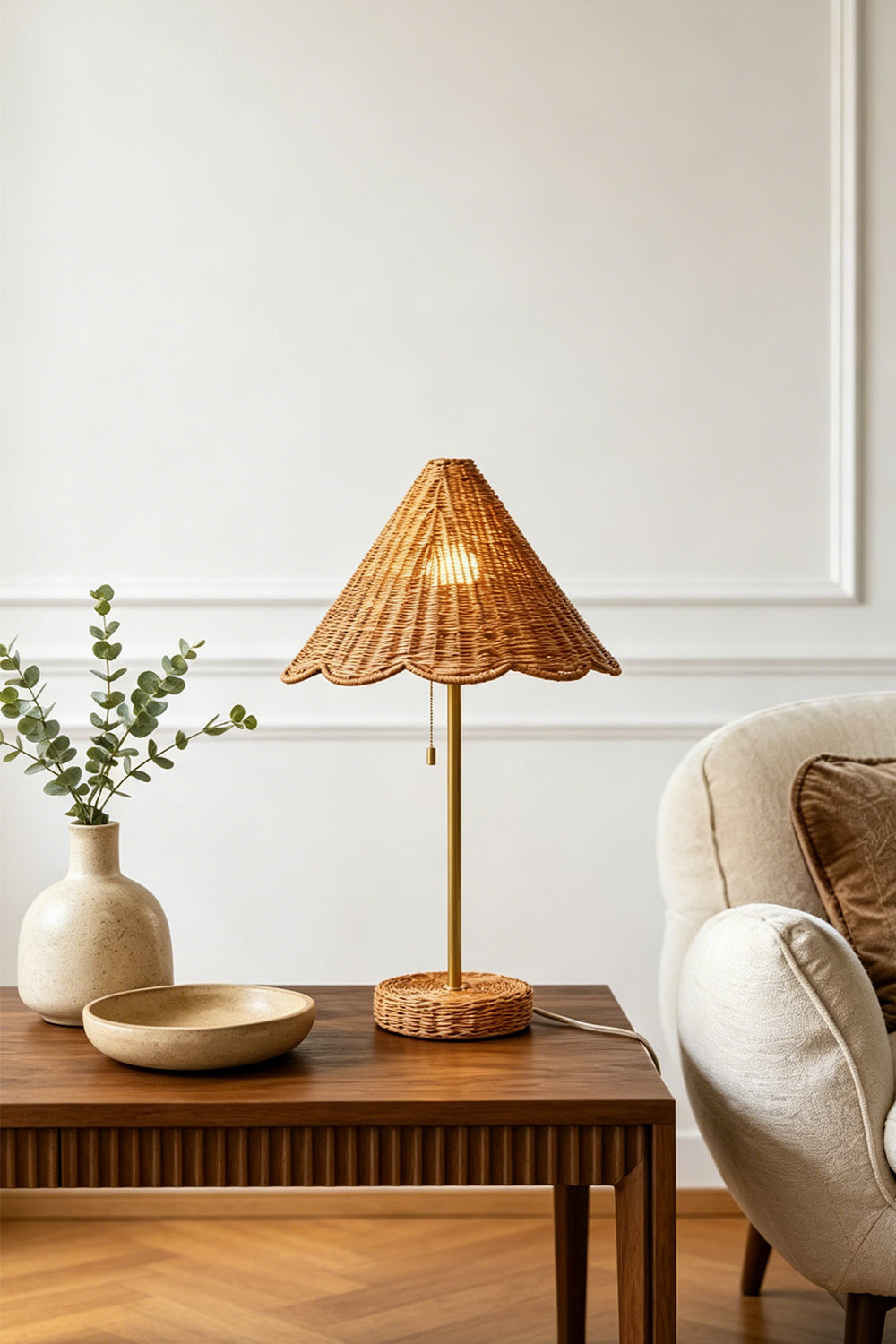 Osrilla Scalloped Rattan Table Lamp | Rattan, Brass | Placed as a charming accent light on a fluted wood bedside table in a room with herringbone hardwood floors and a ceramic vase | vexa lamps