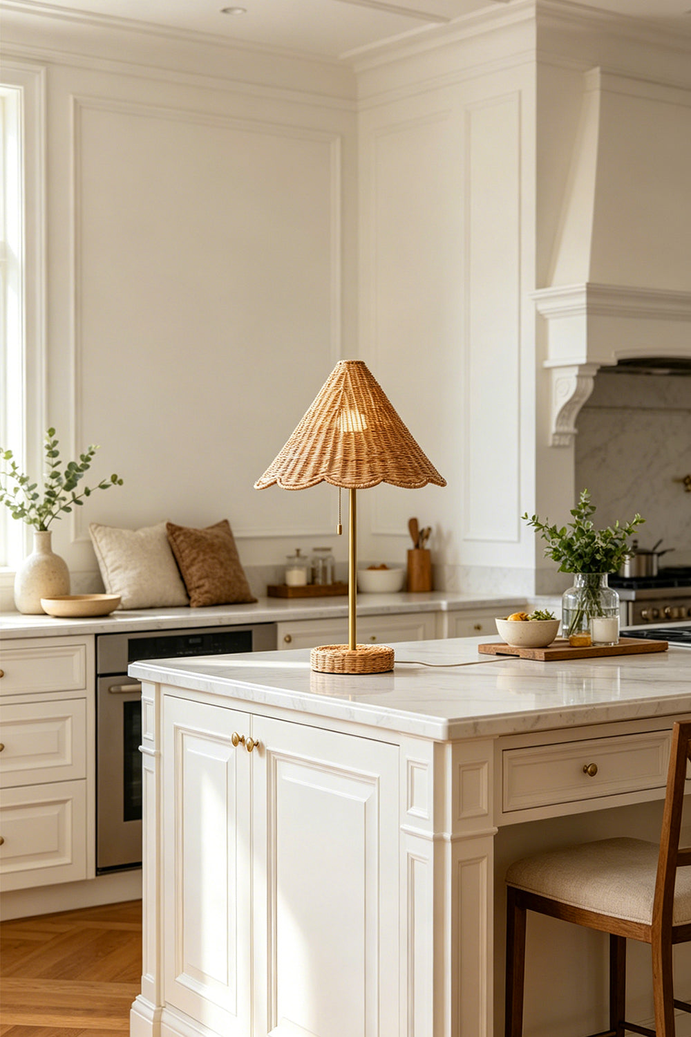 Osrilla Scalloped Rattan Table Lamp | Rattan, Brass | Serving as an elegant decorative light centerpiece on a pristine white marble kitchen island counter under natural daylight | vexa lamps