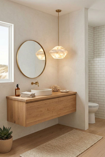 Ottilie Barrel Alabaster Pendant Light | Natural Alabaster and Metal | Installed in a modern bathroom vanity area beside a round mirror | vexa lamps