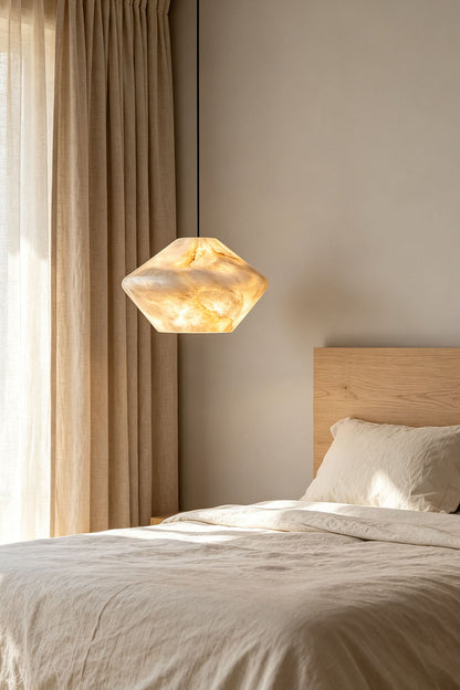 Ottilie Barrel Alabaster Pendant Light | Natural Alabaster and Metal | Styled in a cozy bedroom setting beside a bed with linen curtains | vexa lamps