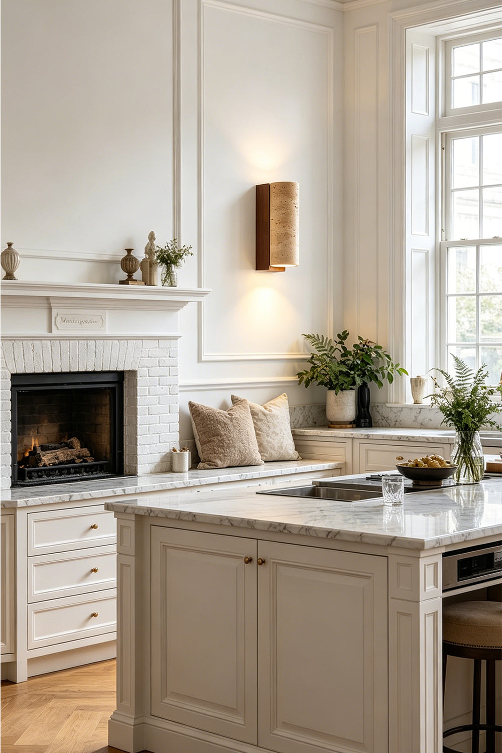 Outcrop Beige Travertine Wall Sconce | Travertine, Metal | Providing cozy ambient illumination on a paneled wall in a contemporary kitchen near a white marble island counter | vexa lamps