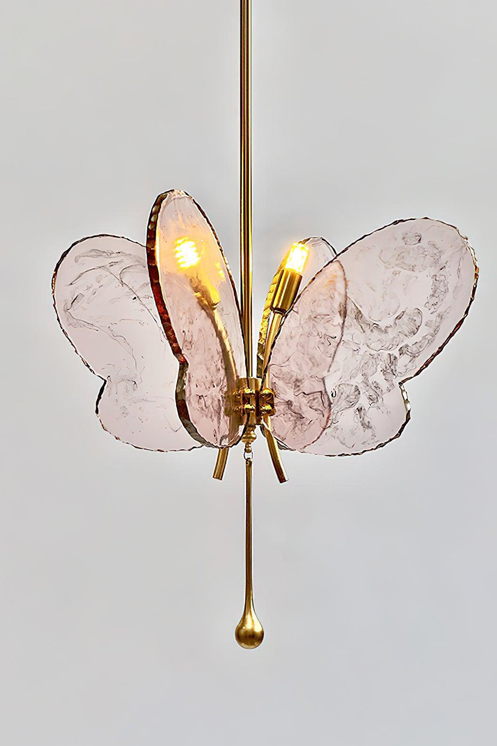 Papillon Glass Butterfly Pendant Lamp | Glass, Metal | Side angled view of the glowing pink glass wings and polished gold brass rod fixture | vexa lamps
