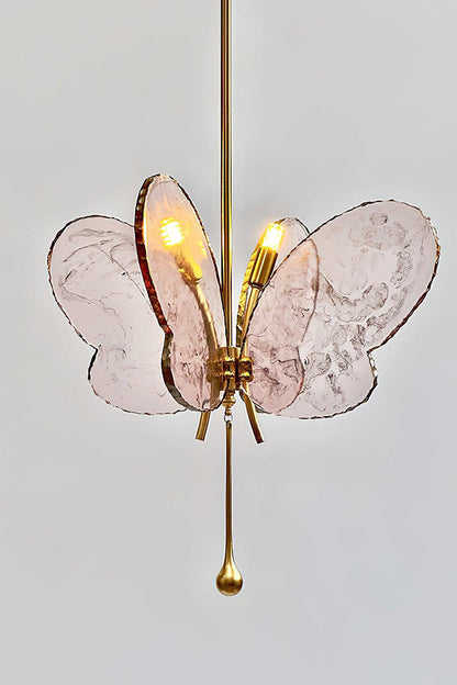 Papillon Glass Butterfly Pendant Lamp | Glass, Metal | Side angled view of the glowing pink glass wings and polished gold brass rod fixture | vexa lamps